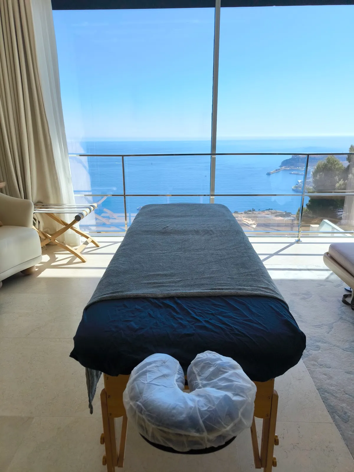 Table de massage installée devant une baie vitrée, face à la mer et à Monaco